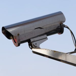 Close-up of an outdoor CCTV camera installed on a wall for security purposes.