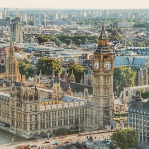 Stunning aerial view of London's iconic Big Ben and the river Thames under daylight.